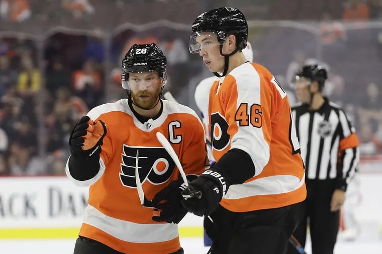 Claude Giroux gives instruction to teammate Mikhail Vorobyev during a preseason game.