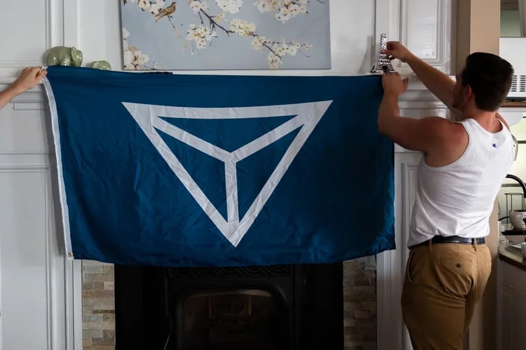 Members of Identity Evropa, many of whom prefer not to be identified, hang their group's flag during a 2018 event. Regional members of the group in Pennsylvania scheduled a meetup in February at a Delaware County bowling alley.
