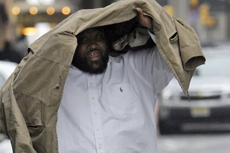 Dwight Dixon looks up from under his jacket after exiting the Criminal Justice Center in Philadelphia on Jan. 28, 2009. (AP File Photo)