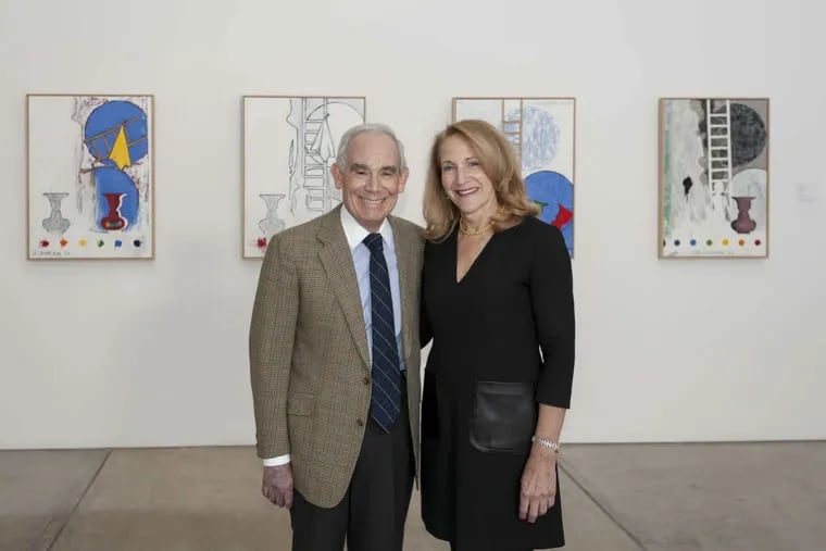 Keith L. and Katherine Sachs stand before in the Anne d’Harnoncourt Gallery of the Philadelphia Museum of Art with 5 Postcards (2011) by Jasper Johns on the wall behind them, part of the Sachs’ promised gift to the museum.