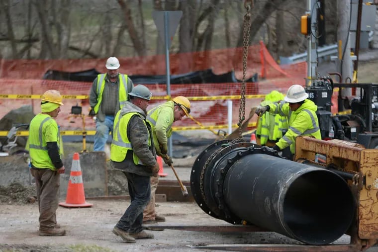 Pipefitters replacing sections of the sewage line that burst at the intersection of Routes 23 and 252 in Valley Forge Park on March 17, spilling an estimated 6.5 million gallons of raw sewage into Valley Creek.