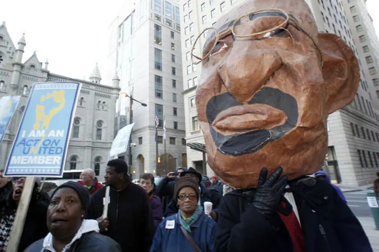 A demonstrator with the a large mask of Philadelphia Mayor Michael Nutter and school supporters protest the possible closer of 29 Philadelphia public schools at City Hall on Tuesday, March 5, 2013. (Yong Kim / Staff Photographer)
