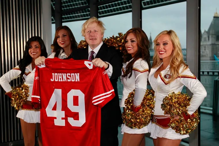 Boris Johnson (center), then Mayor of London, and four of the 49ers cheerleaders posed for the media as the mayor held a team shirt with his name on at City Hall in London on Oct., 26, 2010.