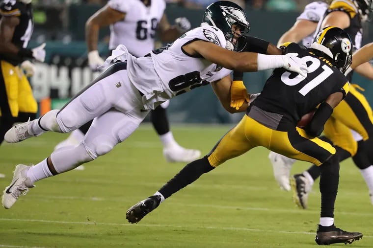 Eagles tight end Richard Rodgers (left) tackling Pittsburgh Steelers cornerback Justin Layne after he intercepted a pass in the third quarter Thursday during a preseason game.