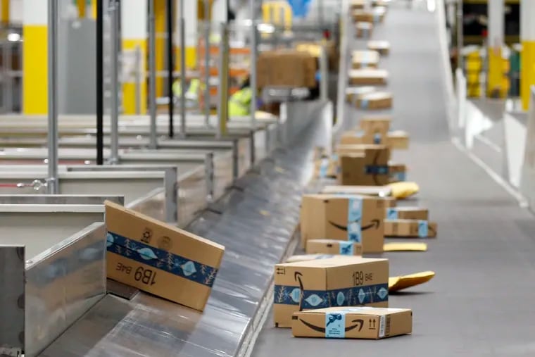 Amazon packages move along a conveyor at an Amazon warehouse facility in Goodyear, Ariz.