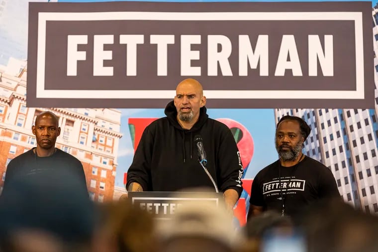 Pennsylvania Lt. Gov. John Fetterman, the Democratic Senate nominee, during his rally Saturday in Philadelphia. He's flanked by Dennis Horton, left, and Lee Horton, right, brothers who Fetterman fought to free from life sentences in prison.