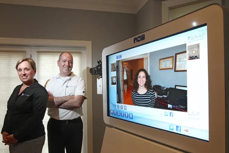 Ellyn Cohen, vice president of sales, and her brother, Ben Bender, franchise owner, show off their TapSnap Phototainment System. (Michael Bryant / Staff Photographer)