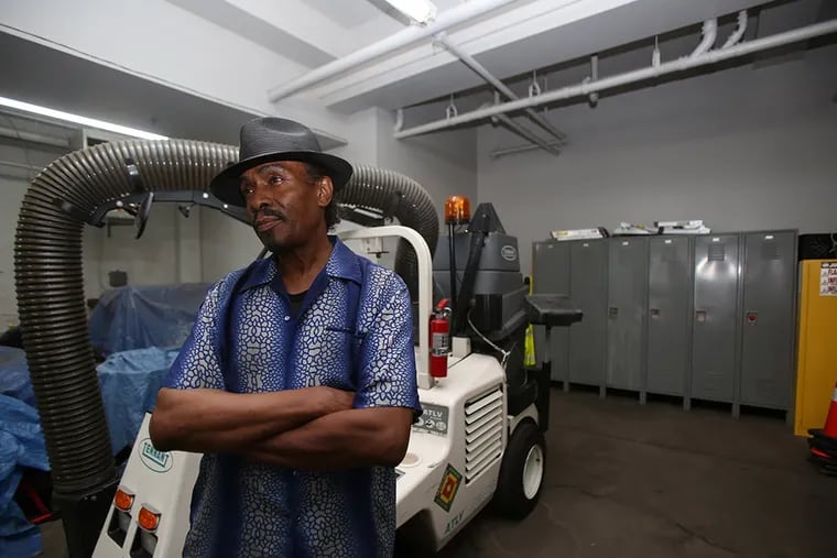 Charles Johnson in the Passyunk Avenue Revitalization Corp. garage in front of a street cleaning machine. ( STEPHANIE AARONSON / Staff Photographer )