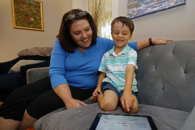 Kim Maguire-Wright, left, interacts with her son, Jack Maguire-Wright, 4, as they play Metamorphabet, on her iPad together.