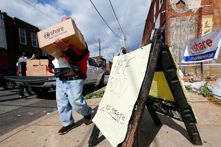 A resident carrying his box of food from the Share Food Program, distributed in the Point Breeze neighborhood of Philadelphia in 2020.