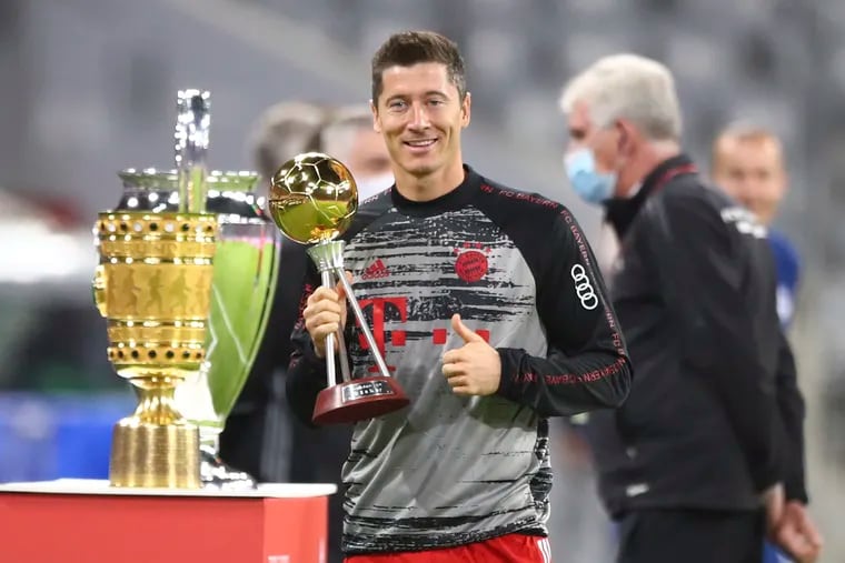 Robert Lewandowski poses with Germany's Player of the Year award and other trophies he helped Bayern Munich win last season before last Friday's Bundesliga season-opening 8-0 rout of Schalke.