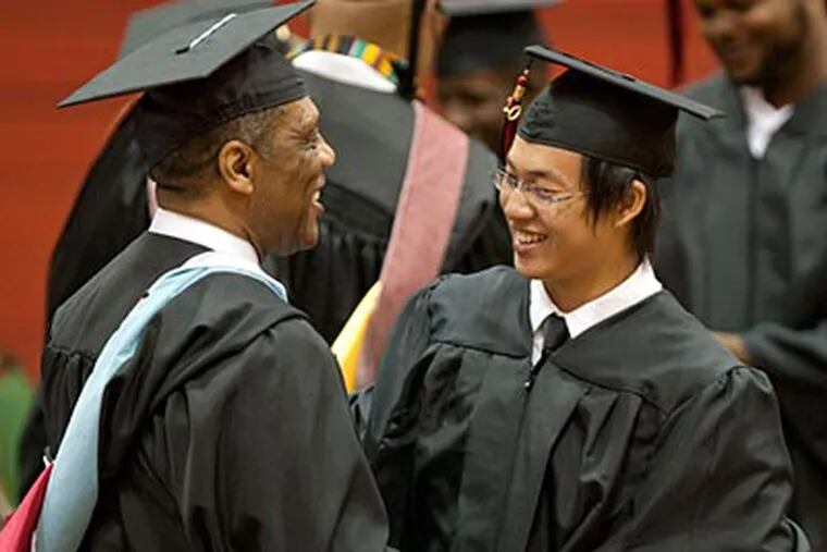 Wei Chen is congratulated by Interim Principal Osborne Wright, Jr. on his way to receive his diploma. (David M Warren / Staff Photographer)