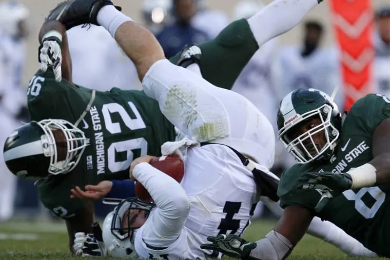 Penn State quarterback Christian Hackenberg, center, is sacked by Michigan State's Joel Heath (92) and Lawrence Thomas, right, during the second quarter of an NCAA college football game, Saturday, Nov. 28, 2015, in East Lansing, Mich.