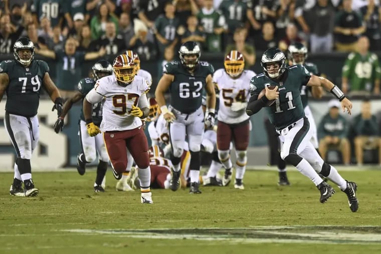 The Eagles quarterback Carson Wentz escapes the scrum behind him — which was a certain sack — and runs 17 yards for a first down during the game against the Washington Redskins at Lincoln Financial Field October 23, 2017. Eagles beat Washington 34-24.
