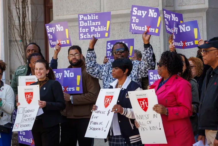 Supporters of funding public schools stand together during a news conference outside Philadelphia City Hall in April. They gathered to speak out against school vouchers.