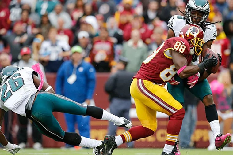The Redskins' Pierre Garcon on catches the football past E.J. Biggers and Walter Thurmond.