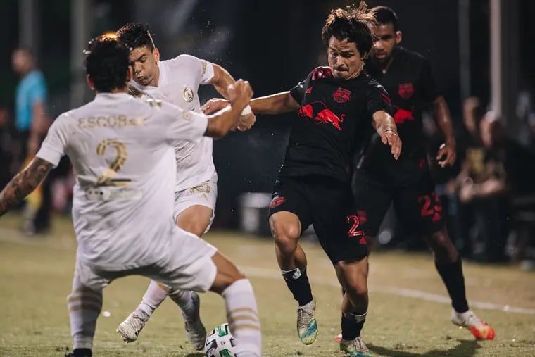 Florian Valot of the New York Red Bulls (right) battles for the ball against Atlanta United's Franco Escobar (front) and Gonzalo Martinez (rear) during a MLS Is Back Tournament game at Disney World's ESPN Wide World of Sports Complex near Orlando, Florida on July 11, 2020.