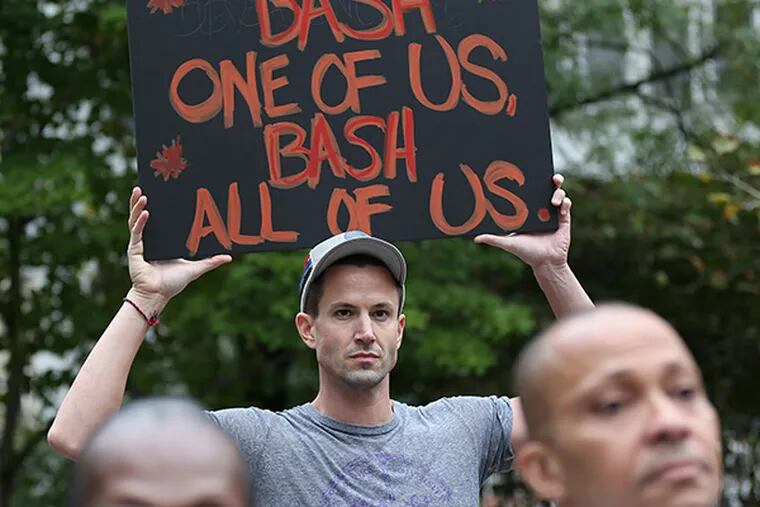 Matt Beierschmitt holds a sign during a rally to support hate-crime legislation at LOVE Park on September 25, 2014, in Philadelphia. ( DAVID MAIALETTI / Staff Photographer )
