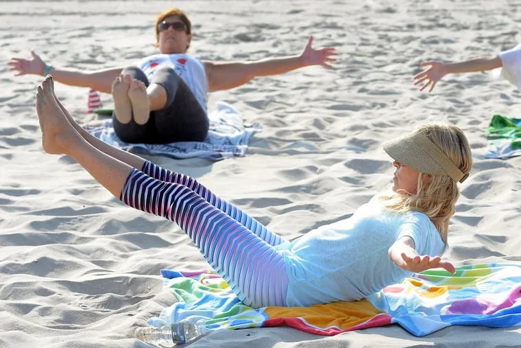 Laura McDonald (front) directs Michelle Friedel during a yoga boot camp.