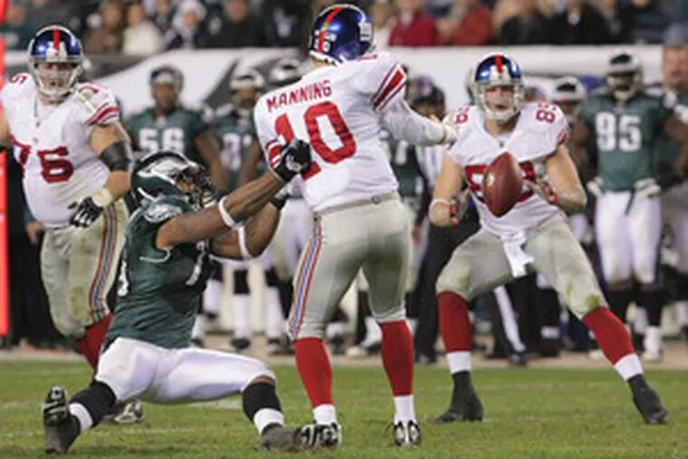 The Eagles&#0039; Juqua Parker causes Giants quarterback Eli Manning to lose the ball, but the play was ruled an incomplete pass.