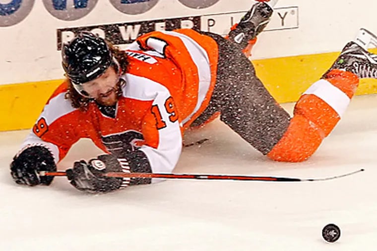 Scott Hartnell dives to the ice in pursuit of a loose puck. (Steven M. Falk/Staff Photographer)