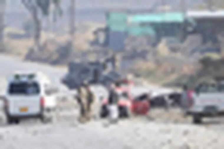 Afghan security forces block the road where Taliban suicide bombers attacked a joint U.S.- Afghan air base in Jalalabad, east of Kabul, Afghanistan on Sunday, Dec. 2, 2012. The suicide bombers attacked early Sunday, detonating explosives at the gate and sparking a gunbattle that lasted at least two hours with American helicopters firing down at militants before the attackers were defeated. (AP Photo/Nasrullah Khan)