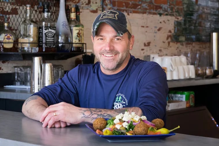 Rob Garpstas behind his bar at Root on West Walnut Street in Lancaster with a Greek salad.