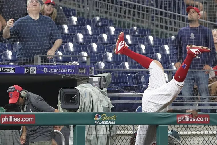 Phillies third baseman Maikel Franco flips over a railing as he goes after a foul ball hit by Adam Eaton of the Nationals in the eighth inning at Citizens Bank Park on Tuesday night.