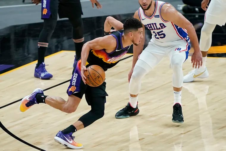 Phoenix Suns guard Devin Booker drives as 76ers guard Ben Simmons (25) defends during the first half of Saturday's game.