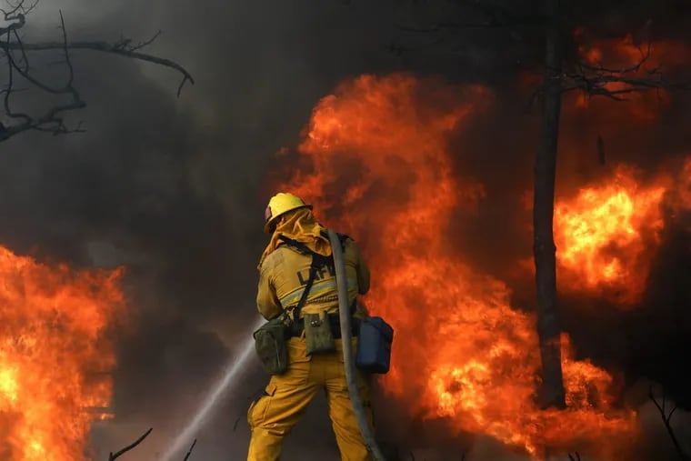 Firefighters try and save a home along Linda Flora Dr. in Bel Air, California, where the Skirball fire prompted a full closure of the 405 Freeway as well as mandatory evacuations in an area of multimillion-dollar homes.