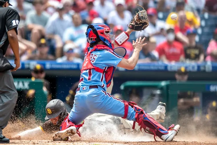 San Diego's Wil Myers scores a run on the sacrifice fly by Ha-Seong Kim as Phillies catcher Garrett Stubbs takes the throw in the fourth inning.