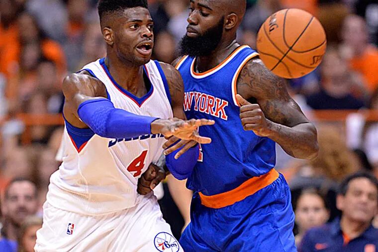 76ers forward Nerlens Noel passes the ball with Knicks forward Quincy Acy. (Mark Konezny/USA Today Sports)