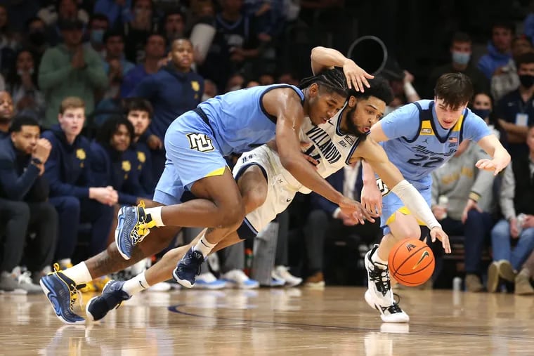 Caleb Daniels, center, of Villanova goes after a loose ball against Justin Lewis, left, and Tyler Kolek of Marquette during the 2nd half on Jan. 19, 2022 at the Finneran Pavilion at Villanova University. The scramble led to the game-winning shot for Lewis and Marquette.