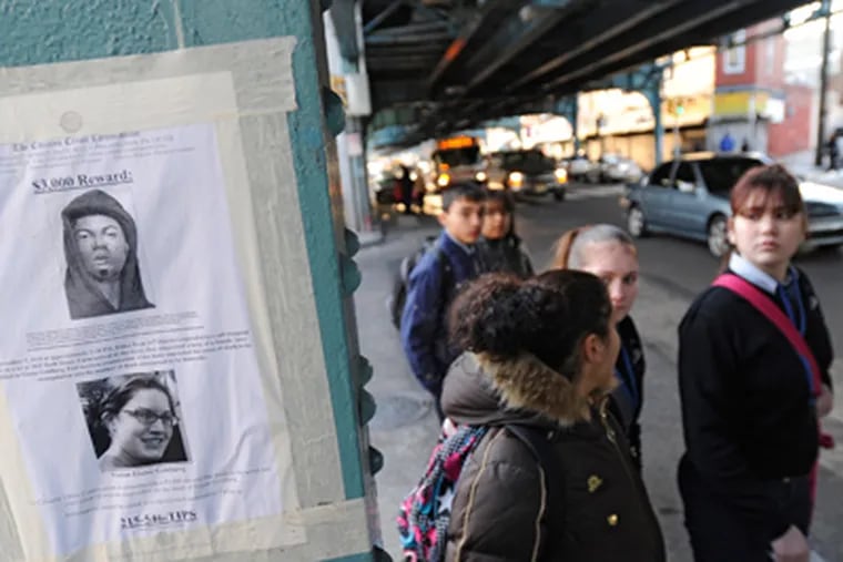 Under the El in Kensington, pedestrians crossing Kensington Avenue pass a Citizens' Crime Commission reward poster for a man wanted for questioning. (Clem Murray / Staff Photographer)