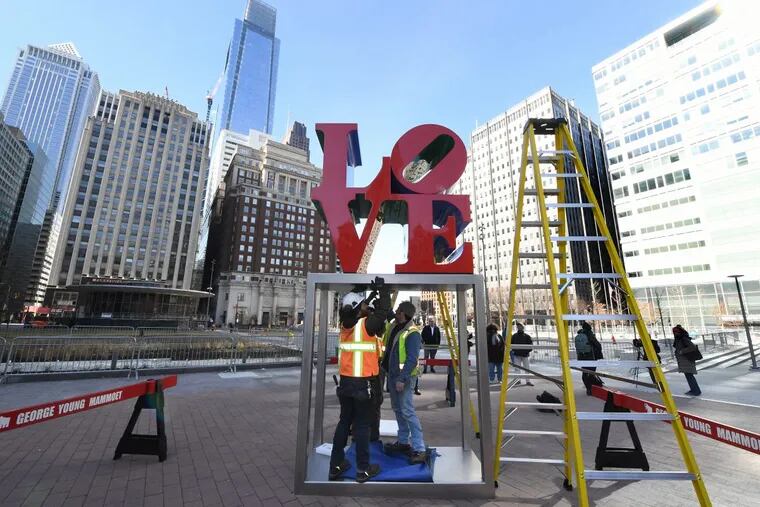 Workers bolt in the LOVE sculpture to JFK Plaza on February 13, 2018.