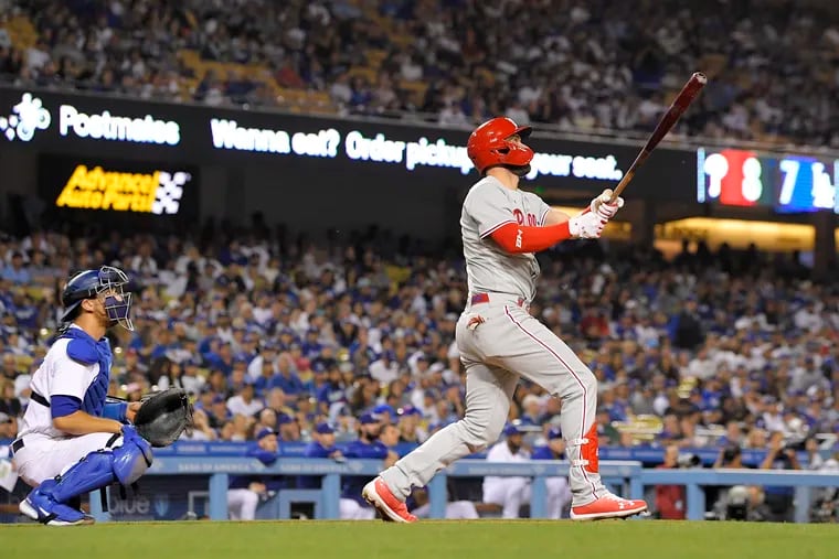 Philadelphia Phillies' Bryce Harper, right, hits a solo home run as Los Angeles Dodgers catcher Austin Barnes watches during the eighth inning of a baseball game Friday, May 13, 2022, in Los Angeles. (AP Photo/Mark J. Terrill)