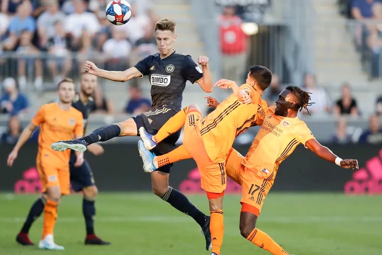 Union defender Jack Elliott leaps after the soccer ball against Houston Dynamo defender Jose Bizama (center) and forward Alberth Elis during the second-half on Sunday, August 11, 2019 in Chester.