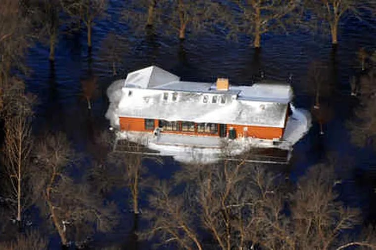 South of Fargo, N.D., a home is surrounded by Red River floodwaters. The river rose yesterday to more than 22 feet above flood stage, surpassing the record high-water mark set in 1897. Freezing temperatures were aiding efforts to protect the city.