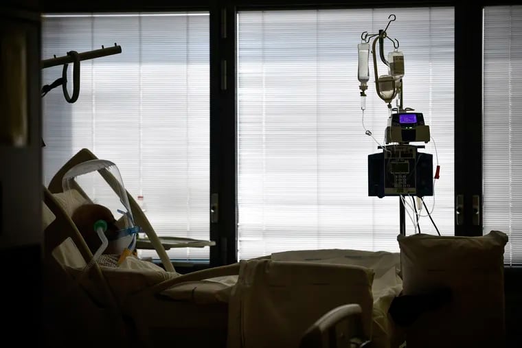 A COVID-19 patient wears a ventilated respiratory device over his head as he lies in a hospital bed at Bergamo's Papa Giovanni XXIII Hospital in Northern Italy.