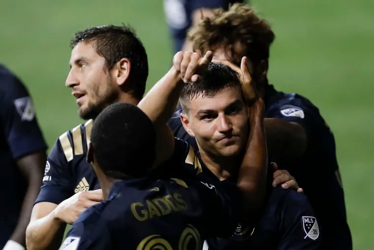 Anthony Fontana celebrates with teammates after scoring the winning goal for the Union against New England.