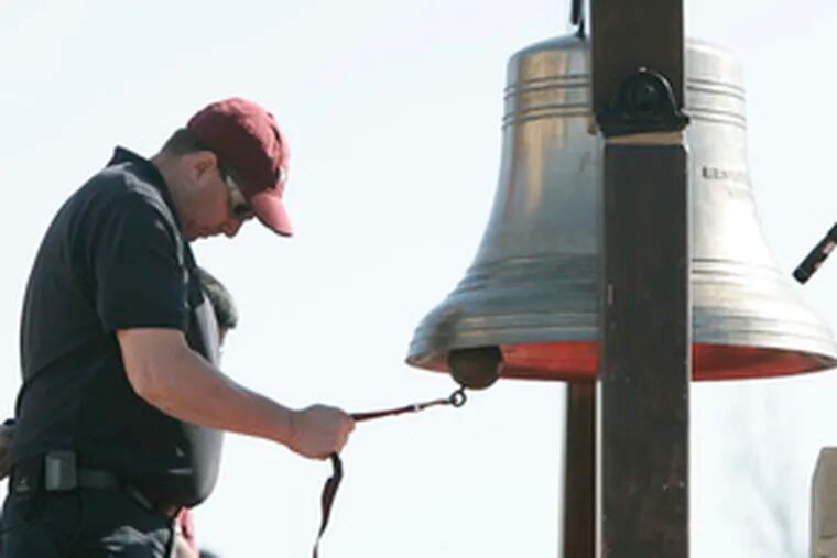 A Virginia Tech employee rings a bell in memory of the dead. The bell was rung 33 times - once for each person who died in the April 16 shootings.