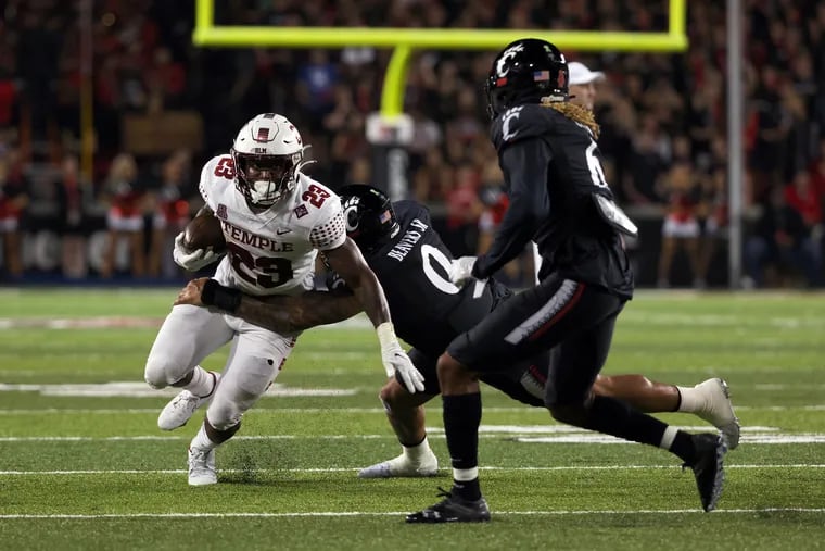 CINCINNATI, OHIO - OCTOBER 08: Edward Saydee #23 of the Temple Owls runs with the ball while being tackled by Darrian Beavers #0 and Bryan Cook #6 of the Cincinnati Bearcats in the second quarter at Nippert Stadium on October 08, 2021 in Cincinnati, Ohio. (Photo by Dylan Buell/Getty Images)