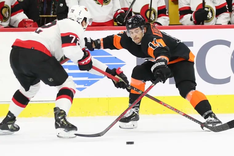 Flyers right wing Travis Konecny reaches for the puck against Ottawa Senators defenseman Thomas Chabot on Dec. 18.