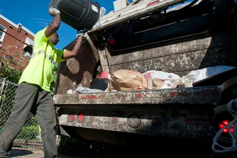 Philadelphia trash collector Mamadou Sacko empties a trash can on a route in the Northeast in 2018.