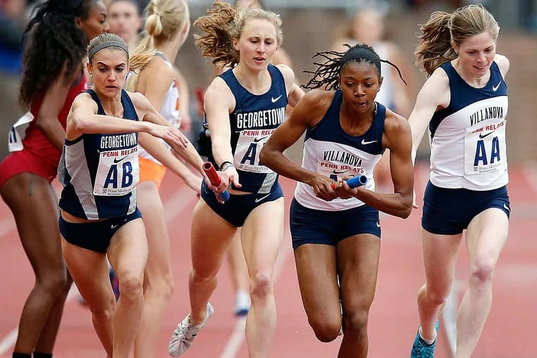 Villanova's Sidney Hayes (second right) holds the baton from teammate
Siofra Cleirigh Buttner (far right) as Georgetown's Heather Martin (far left) receives the baton form teammate Andrea Keklak (second left) in the second leg of the Penn Relays College Women's Distance Medley Championship of America Invitational.