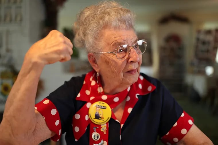 Mae Krier, 93, who lives in Levittown, strikes a pose made famous by a World War II-era poster of a character known as Rosie the Riveter. Krier herlself was a riveter who helped make B-17 bombers during the war. Krier has been working to get a congressional gold medal for all the women who worked in factories to build ships, planes, and armaments for the war effort. Collectively, they're known as Rosie the Riveters.