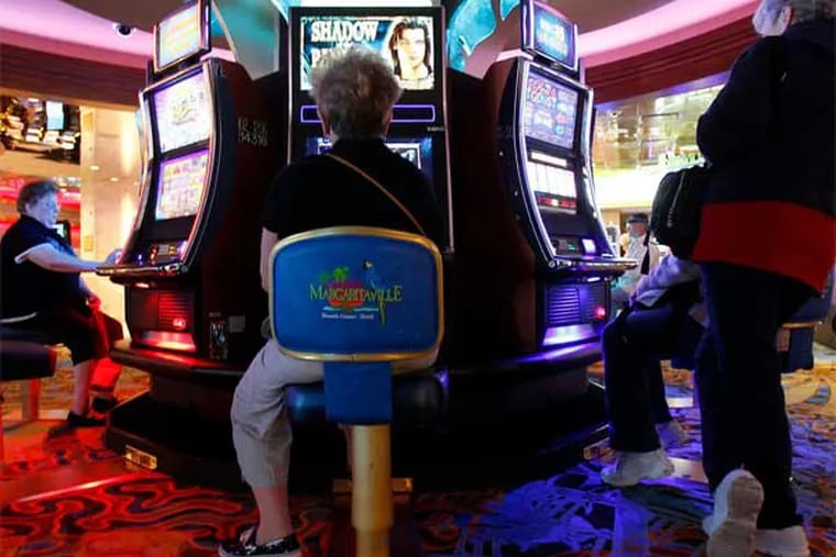 Patrons play slot machines before the opening of Margaritaville at Resorts casino. (David Maialetti / Staff Photographer)