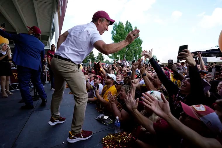 Josh Harris, the leader of a group buying the Washington Commanders, high-fives fans during a pep rally Friday at FedEx Field in Landover, Md.