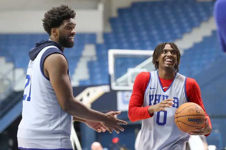 The Sixers' Tyrese Maxey and Joel Embiid joke around as they attempt free-throws with their eyes closed after practice at training camp.