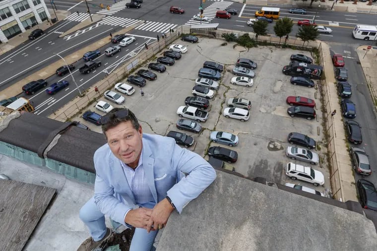 Eric Blumenfeld sits on the roof of the Mural Lofts apartment building, high above the parking lot at Broad and Spring Garden where he is looking to develop an apartment and office tower that would be Philadelphia's tallest building outside its central core.